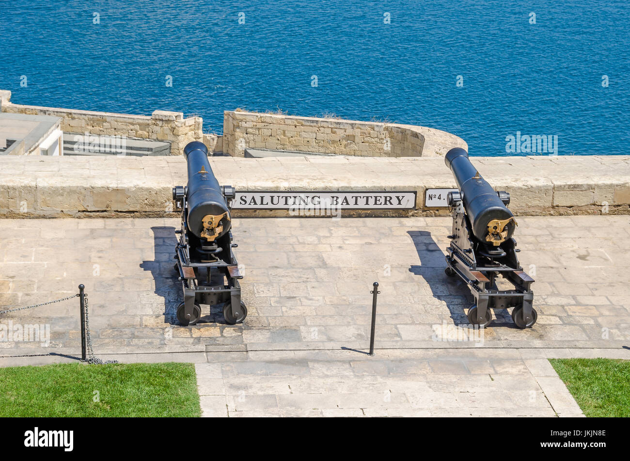 Due degli otto lavoro pistole cerimoniale della batteria a salve di cannone antincendio segnali giornalieri, come si vede dalla Upper Barrakka Gardens a La Valletta, ma Foto Stock