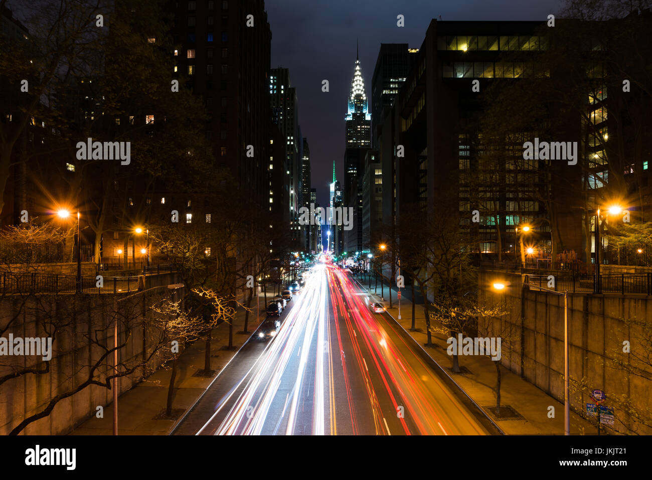 East 42th Street di notte da Tudor City con i fari del traffico su strada con il Chrysler Building in background, New York Foto Stock