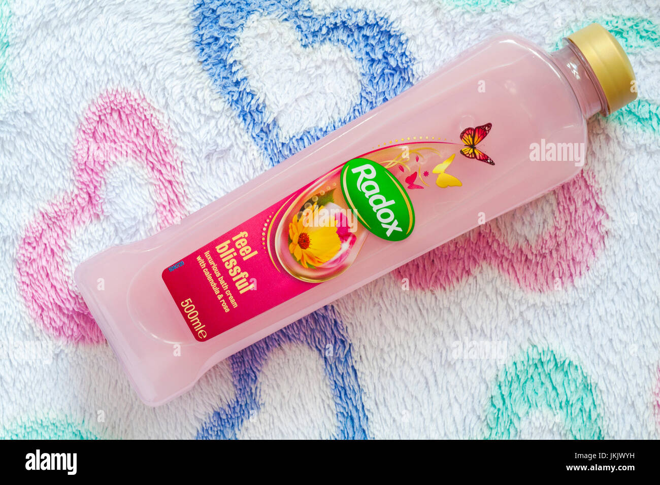Bottiglia di Radox sento beata bagno lussuoso con crema di calendula & rose su asciugamano Foto Stock