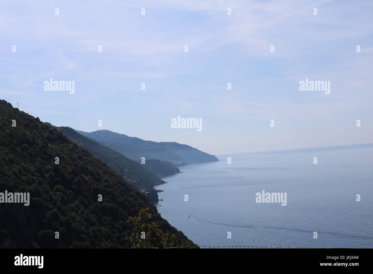 Allo sbiadimento cliffside e riva del mare lungo di essa si vede durante una passeggiata tra le città in Cinque Terre, Italia Foto Stock