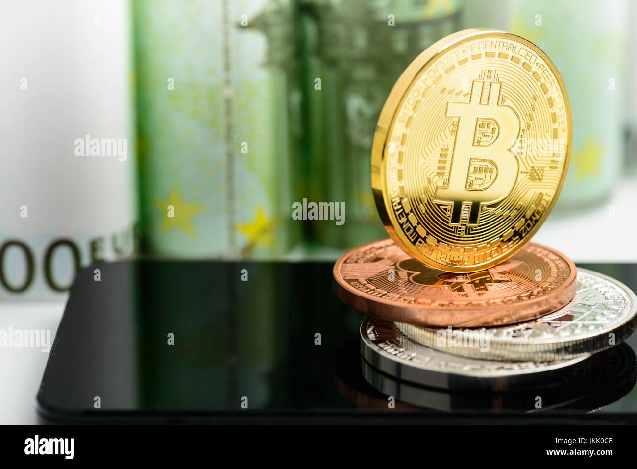Golden Bitcoin sullo smartphone su banconote denaro sfondo Foto Stock
