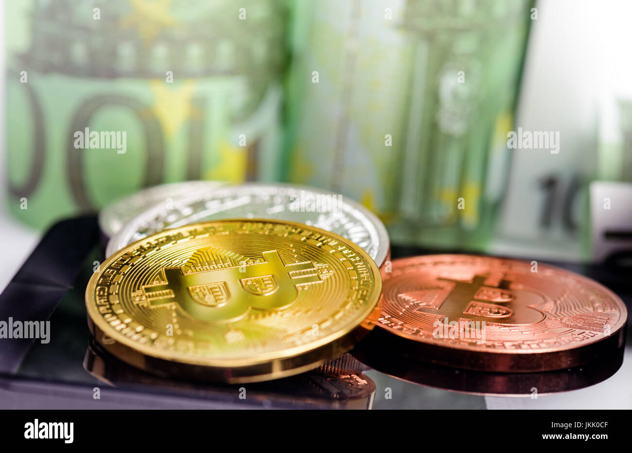 Bitcoin monete sullo smartphone su banconote denaro sfondo Foto Stock