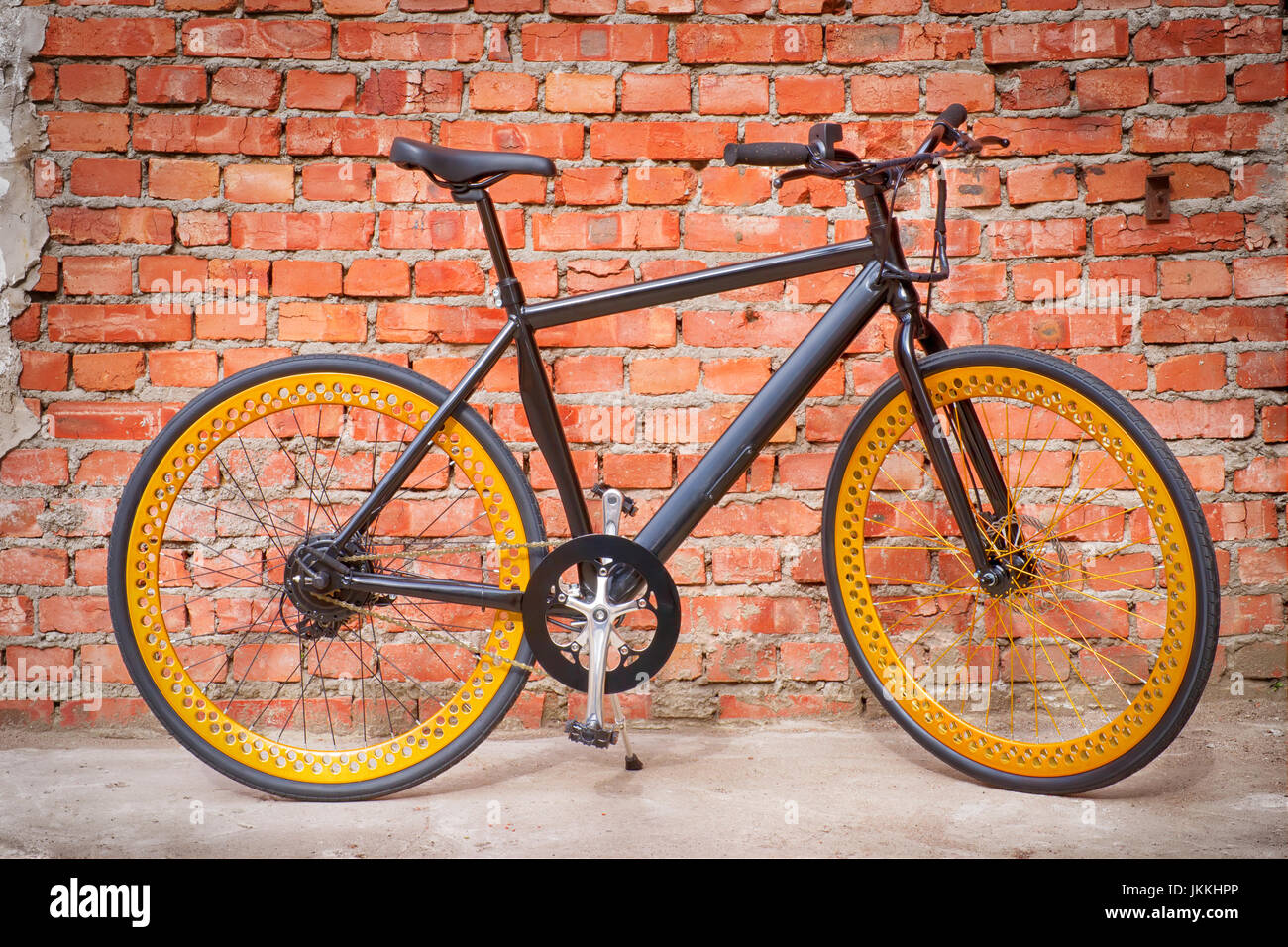Nero bicicletta elettrica contro un muro di mattoni Foto Stock