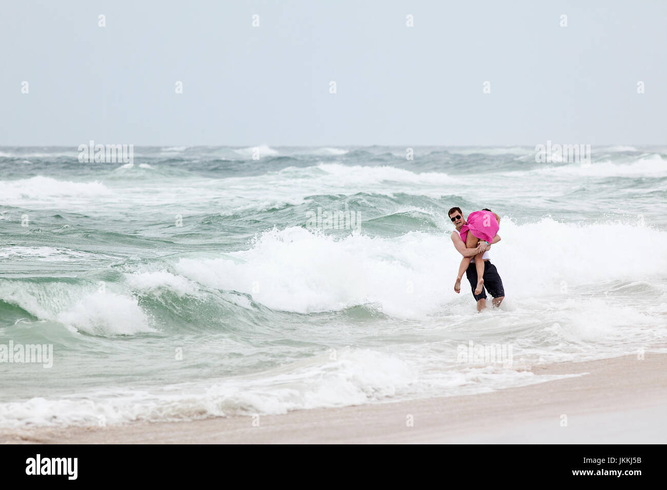 Panama City Beach, Florida. Spring Break, 2011. L uomo si porta la fidanzata in acqua. Foto Stock