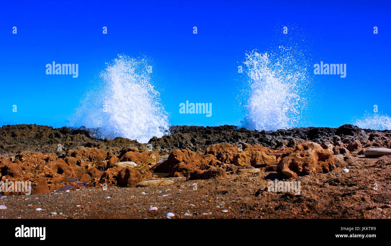 Onde sparare attraverso le aperture nella roccia a rocce di soffiaggio spiaggia di Jupiter, Florida. Foto Stock