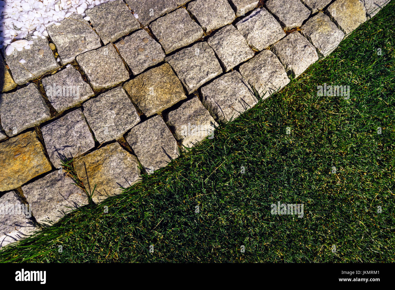 Bella passerella vista da sopra il bordo di una pietra e un bellissimo prato. Composizione diagonale. Foto Stock