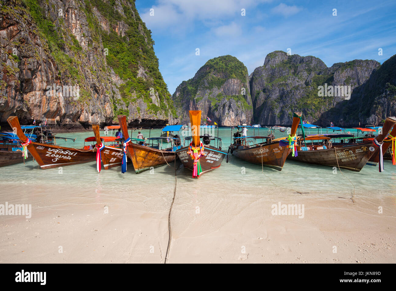 KRABI, Tailandia - 4 DICEMBRE : colorato long tail barche alla bellissima spiaggia su uno sfondo di cielo blu e azzurro mare e rocce calcaree, Phi Phi Isla Foto Stock