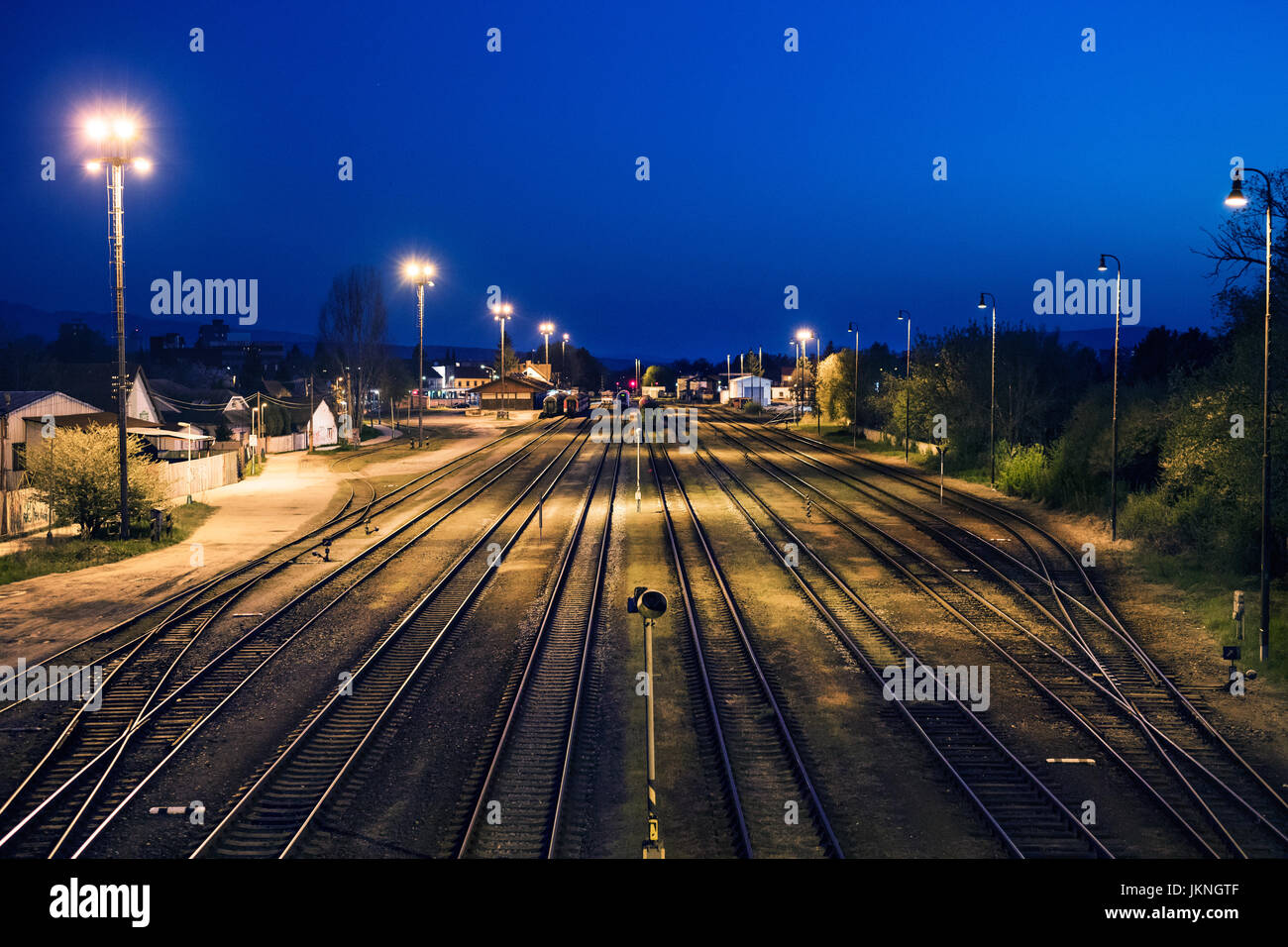 I binari della ferrovia in prossimità del magazzino sotto il cielo di notte. Foto Stock