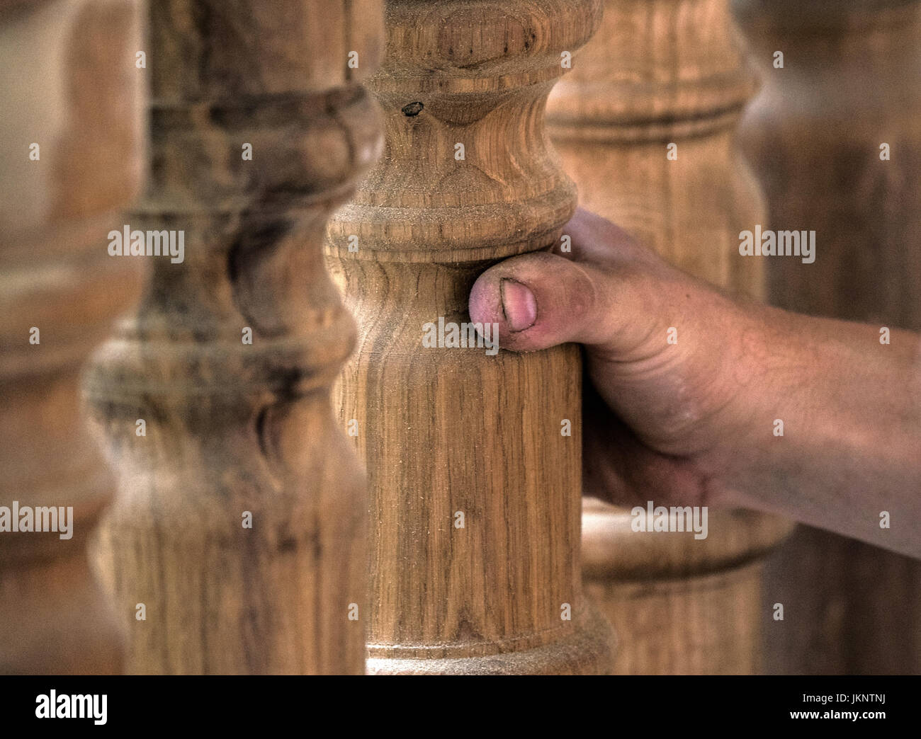 Un falegname controlla le colonne woodturned della ringhiera in Frankfurt am Main, Germania, 24 luglio 2017. Un funzionario la visualizzazione del finito pergola in legno nella corte "Hinter Laemmchen dem' ha avuto luogo - il progetto è parte di una grande città di scala nel progetto di costruzione del centro storico di Francoforte. La parte interna della città fu distrutta attraverso incursioni aeree della seconda guerra mondiale, come pure nel dopoguerra. Il progetto di costruzione sarà parzialmente ricostruire la storica citta' interna. Foto: Andreas Arnold/dpa Foto Stock