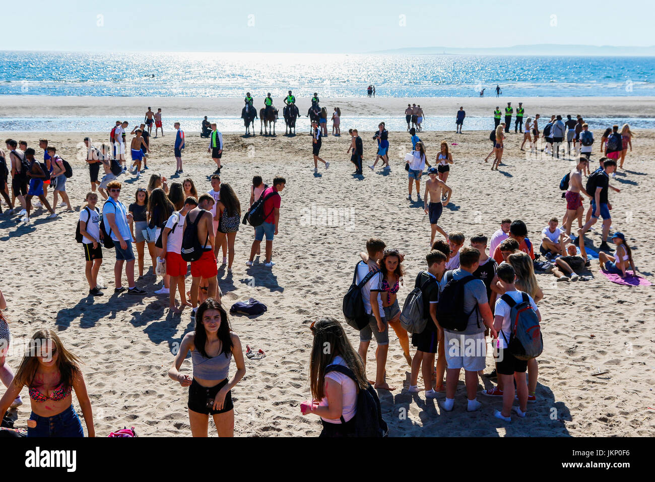 Troon, Ayrshire, Regno Unito. Il 24 luglio, 2017. Più di duemila persone per la maggior parte degli adolescenti, ha visitato la spiaggia di South Beach a Troon in risposta ad un invito aperto, attraverso Facebook a un party in spiaggia e per approfittare del sole calde temperature estive. Dopo un simile Facebook beach party la settimana precedente quando vi è stato diversi arresti per la polizia disturbi la Scozia ha dato molta attenzione per la zona, ma questa volta non ci sono stati arresti e la presenza delle forze di polizia i cavalli hanno dimostrato di essere buoni relazioni pubbliche. Credito: Findlay/Alamy Live News Foto Stock