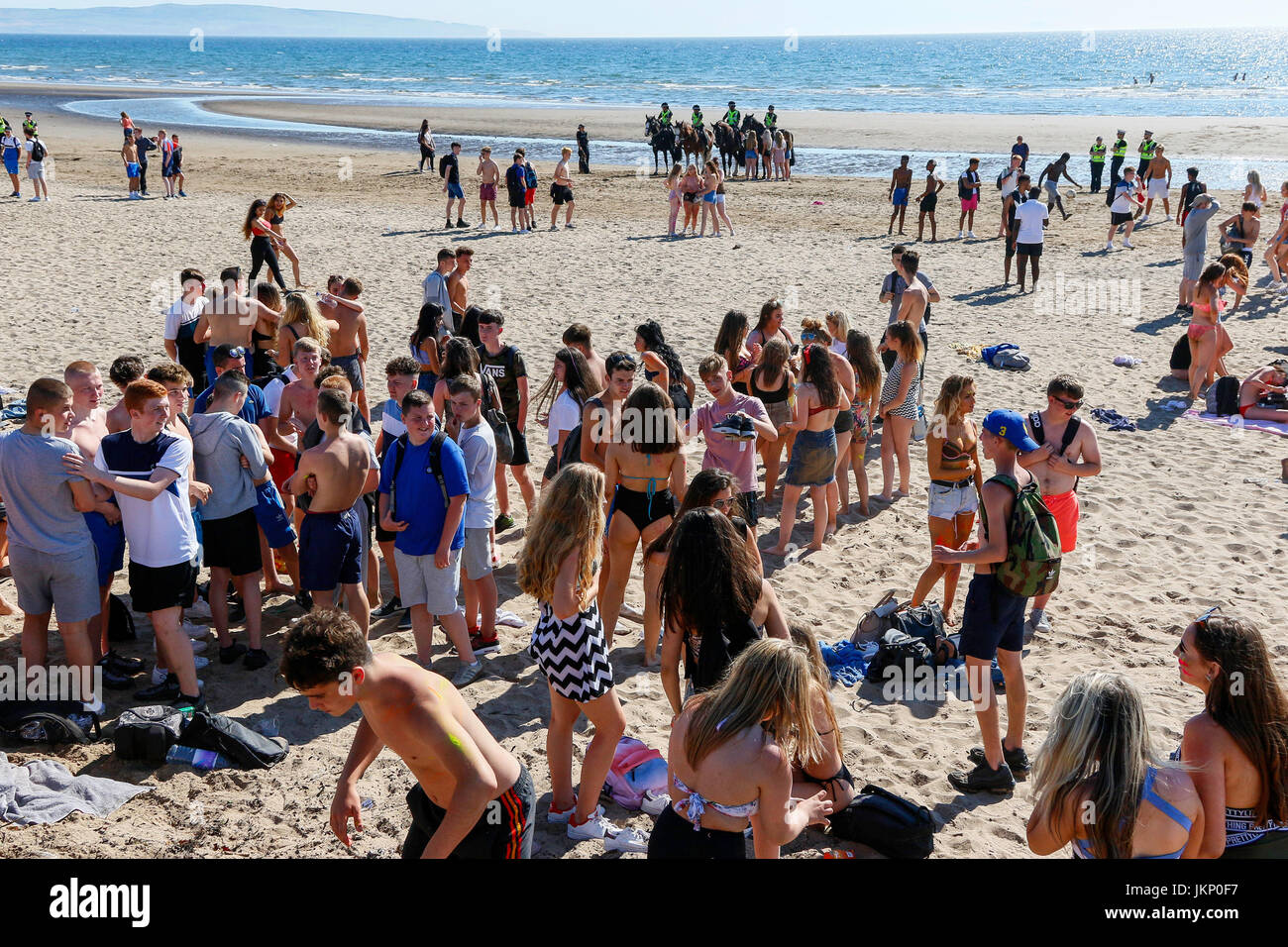 Troon, Ayrshire, Regno Unito. Il 24 luglio, 2017. Più di duemila persone per la maggior parte degli adolescenti, ha visitato la spiaggia di South Beach a Troon in risposta ad un invito aperto, attraverso Facebook a un party in spiaggia e per approfittare del sole calde temperature estive. Dopo un simile Facebook beach party la settimana precedente quando vi è stato diversi arresti per la polizia disturbi la Scozia ha dato molta attenzione per la zona, ma questa volta non ci sono stati arresti e la presenza delle forze di polizia i cavalli hanno dimostrato di essere buoni relazioni pubbliche. Credito: Findlay/Alamy Live News Foto Stock