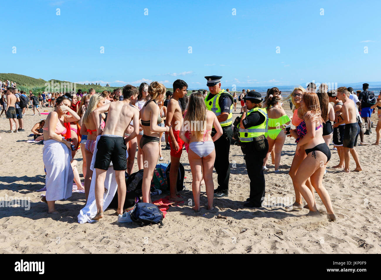 Troon, Ayrshire, Regno Unito. Il 24 luglio, 2017. Più di duemila persone per la maggior parte degli adolescenti, ha visitato la spiaggia di South Beach a Troon in risposta ad un invito aperto, attraverso Facebook a un party in spiaggia e per approfittare del sole calde temperature estive. Dopo un simile Facebook beach party la settimana precedente quando vi è stato diversi arresti per la polizia disturbi la Scozia ha dato molta attenzione per la zona, ma questa volta non ci sono stati arresti e la presenza delle forze di polizia i cavalli hanno dimostrato di essere buoni relazioni pubbliche. Credito: Findlay/Alamy Live News Foto Stock