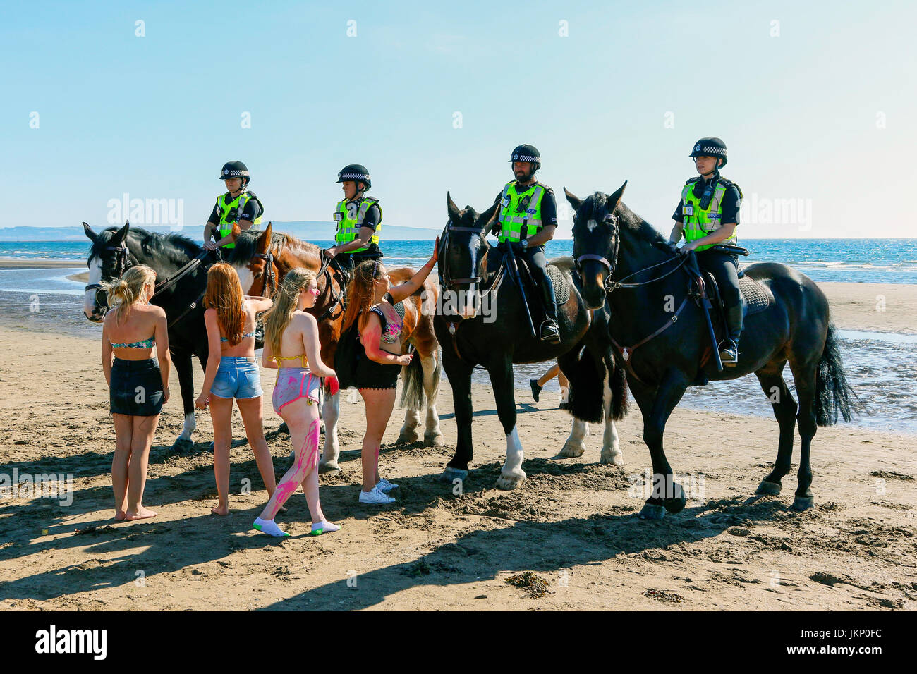 Troon, Ayrshire, Regno Unito. Il 24 luglio, 2017. Più di duemila persone per la maggior parte degli adolescenti, ha visitato la spiaggia di South Beach a Troon in risposta ad un invito aperto, attraverso Facebook a un party in spiaggia e per approfittare del sole calde temperature estive. Dopo un simile Facebook beach party la settimana precedente quando vi è stato diversi arresti per la polizia disturbi la Scozia ha dato molta attenzione per la zona, ma questa volta non ci sono stati arresti e la presenza delle forze di polizia i cavalli hanno dimostrato di essere buoni relazioni pubbliche. Credito: Findlay/Alamy Live News Foto Stock