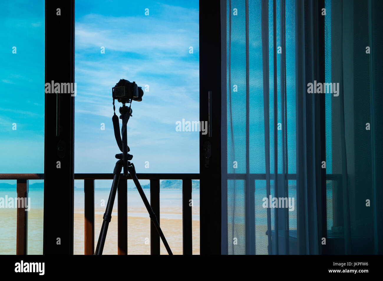 Silhouette fotocamera su treppiede a portico al di fuori della camera di mattina che può sparare bella vista del paesaggio da remoto o wireless in qualsiasi momento, Foto Stock