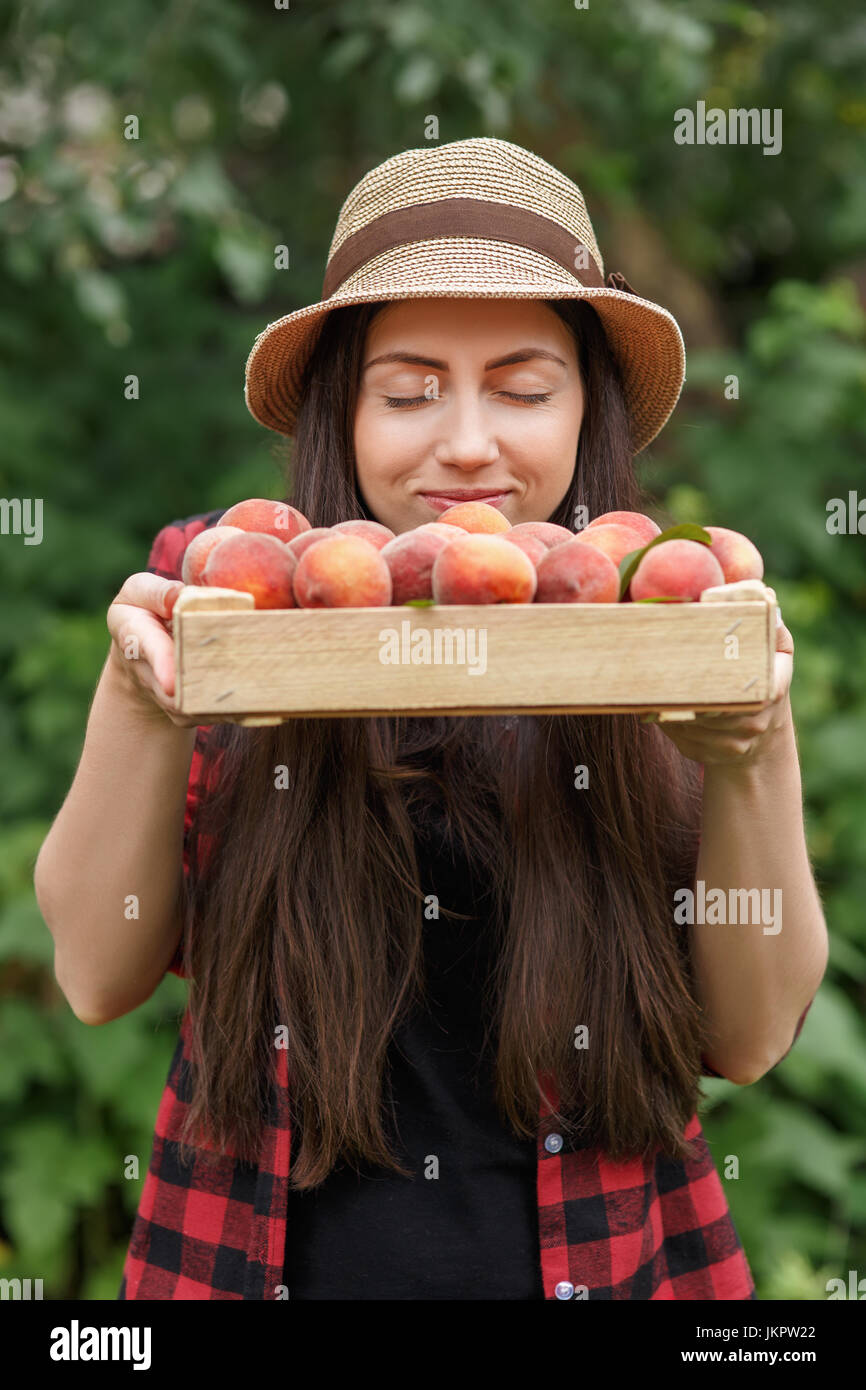 Donna giardiniere con pesche Foto Stock