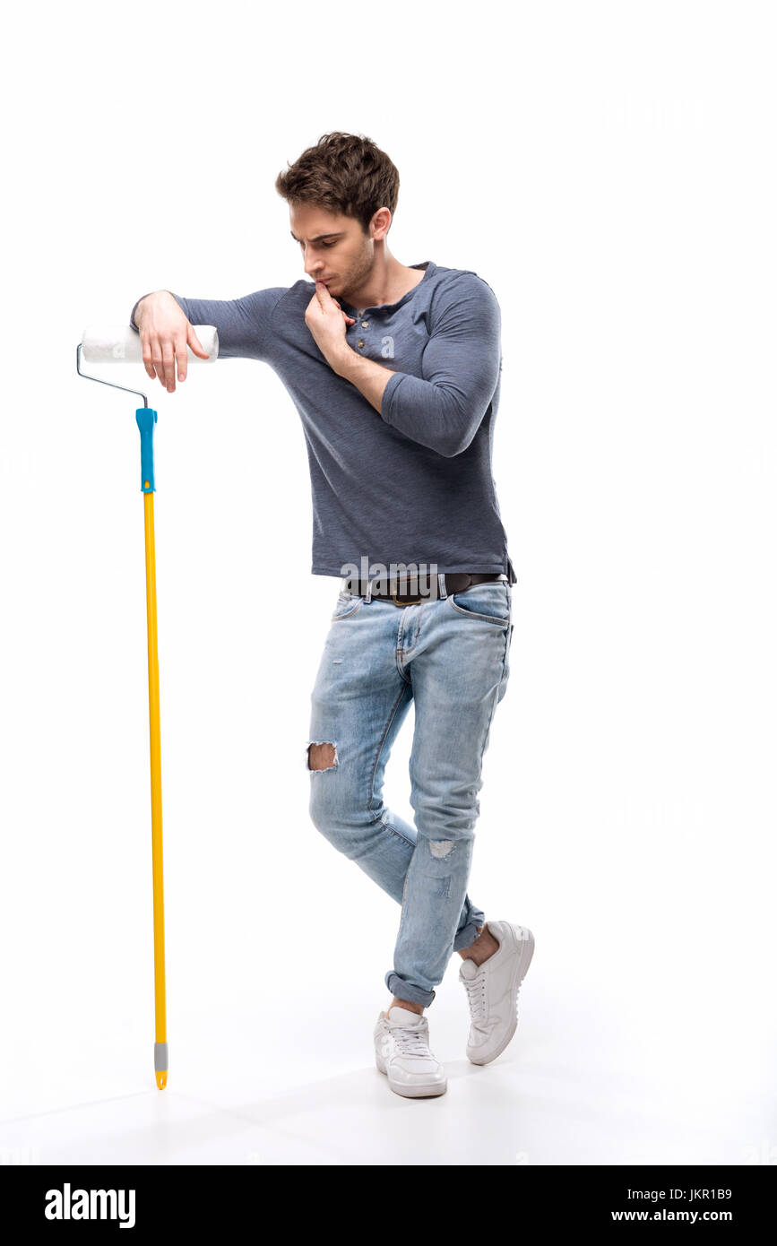 Malinconici uomo bello holding rullo di vernice e isolato su bianco, tuttofare concetto strumenti Foto Stock