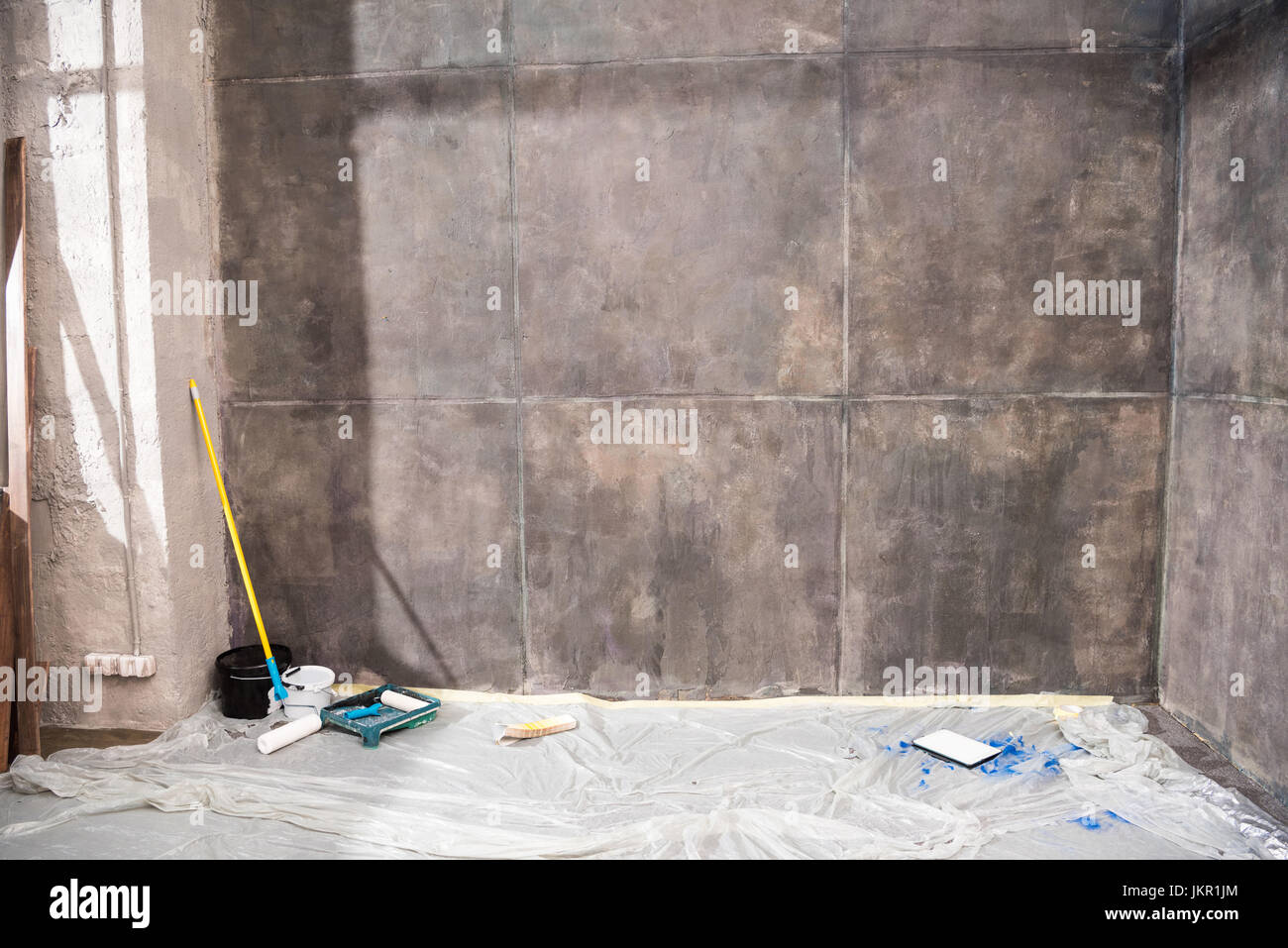 Stanza vuota con pareti grigie e gli strumenti per il rinnovo, il concetto di rinnovamento Foto Stock