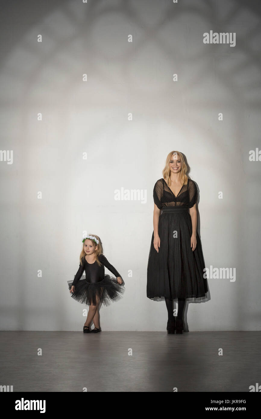 Ritratto di Madre e figlia in costume nero in piedi contro la parete a dance studio Foto Stock