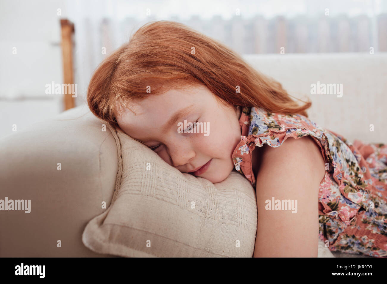 Carino ragazza dorme sul divano di casa Foto Stock