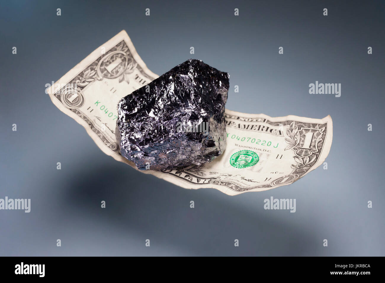 Close-up di Shiny Stone su American un dollaro la levitazione su sfondo grigio Foto Stock