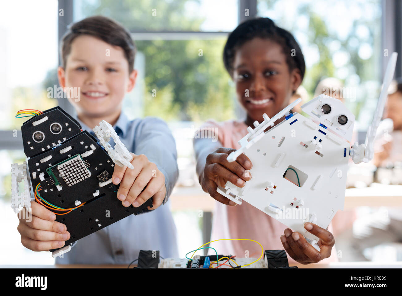 I bambini con i modelli di robot di sorridere alla telecamera Foto Stock