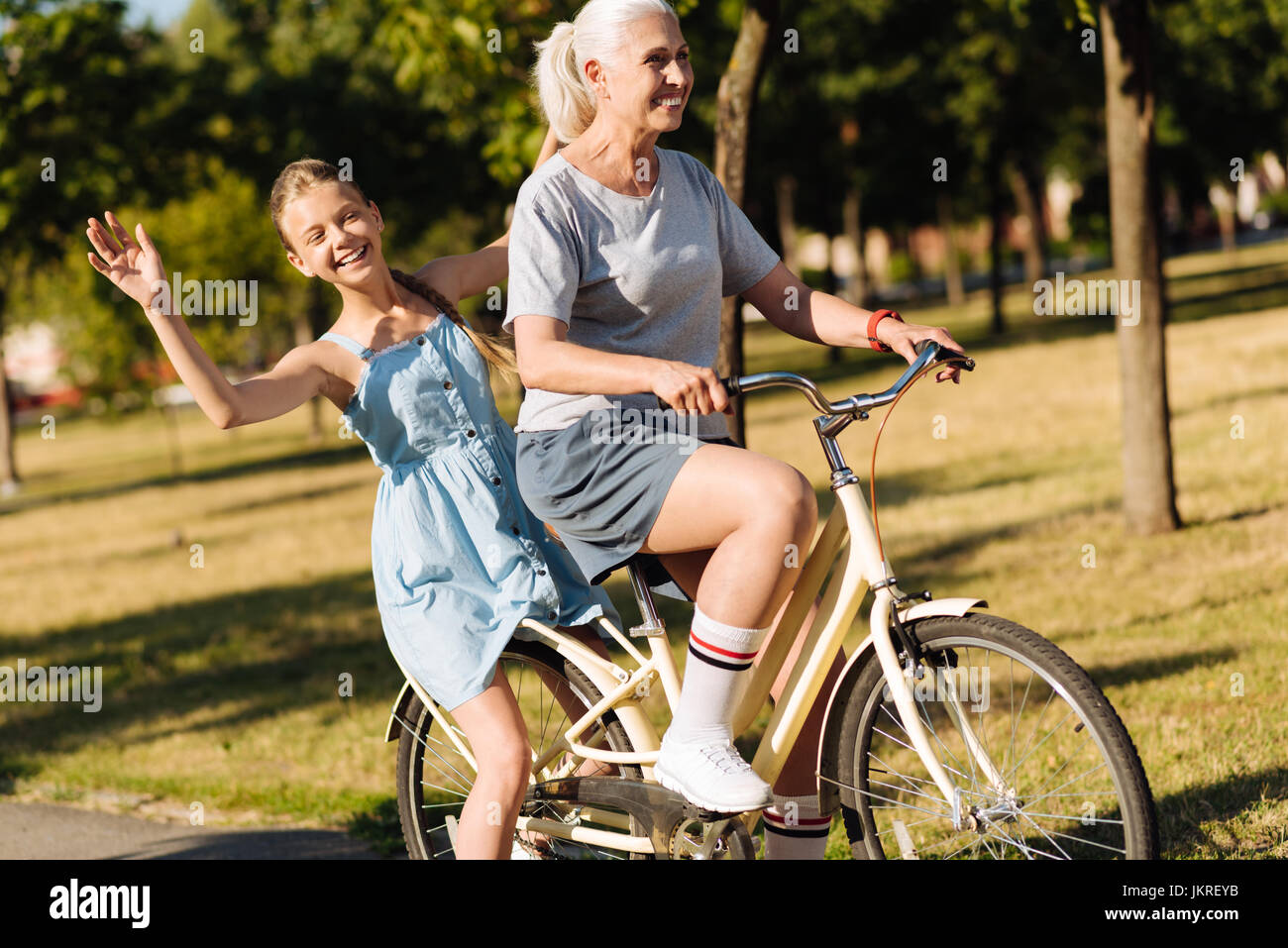 Overjoyed bella ragazza seduta sul retro sit della bicicletta Foto Stock