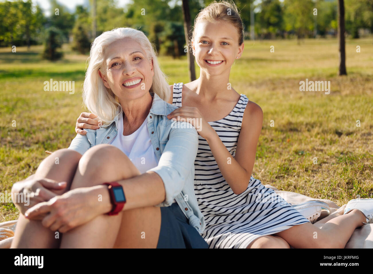 Gioiosa senior donna seduta nel parco con la sua nipote carino Foto Stock
