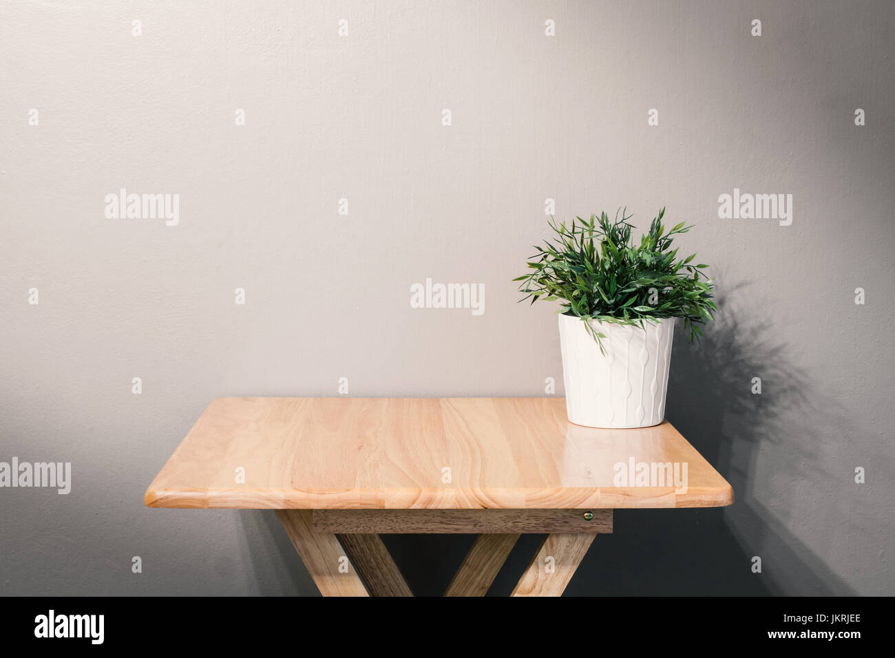Svuotare tavolo in legno con impianto di pot su sfondo grigio Foto Stock