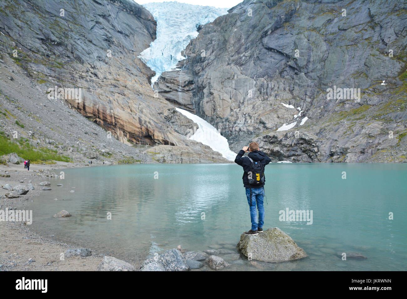 Uomo di scattare una foto del ghiacciaio briksdal, il più grande ghiacciaio d'Europa, olden Norvegia Foto Stock
