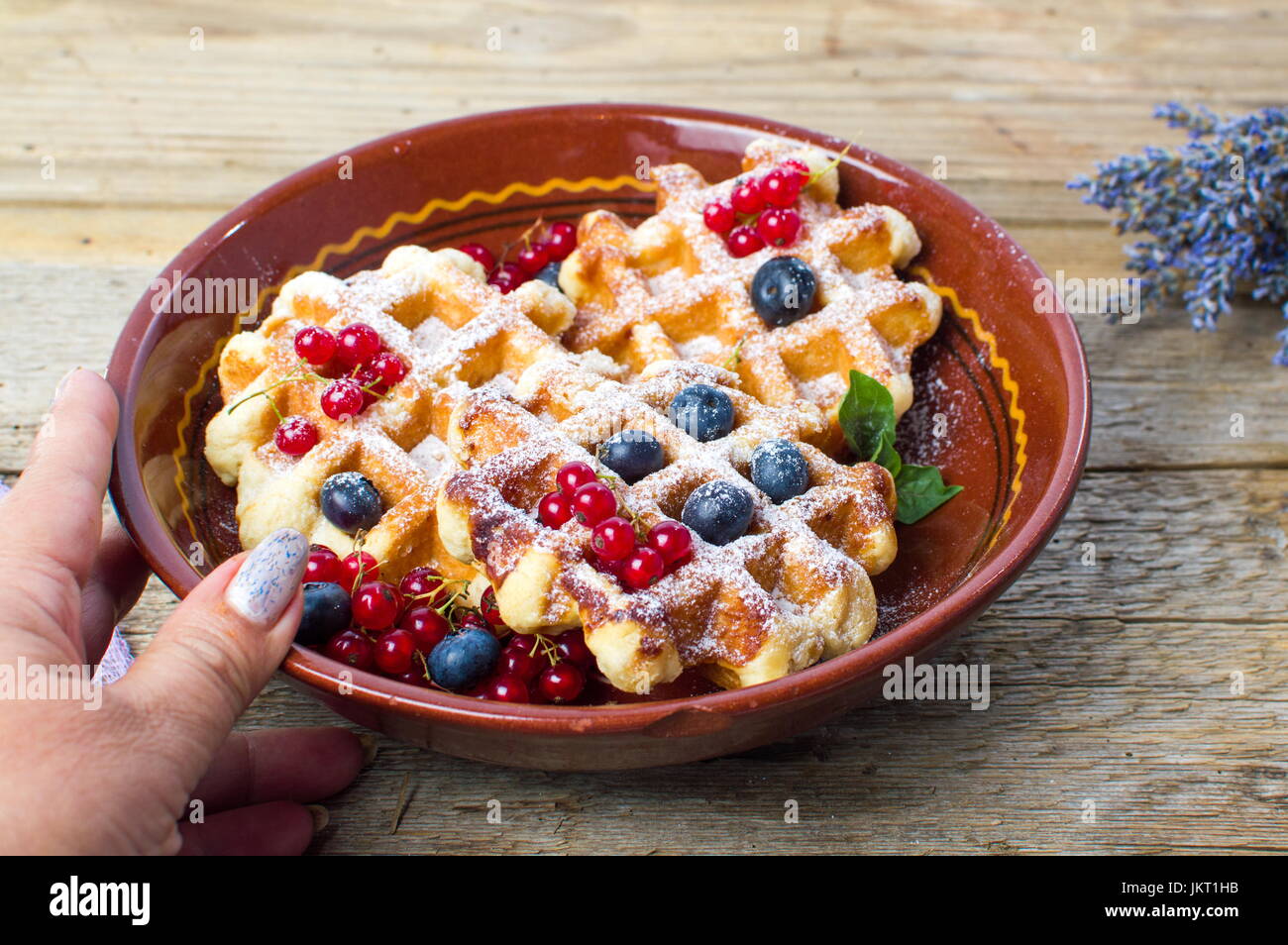 Servendo femmina waffles fatti in casa con prodotti freschi frutti di bosco Foto Stock