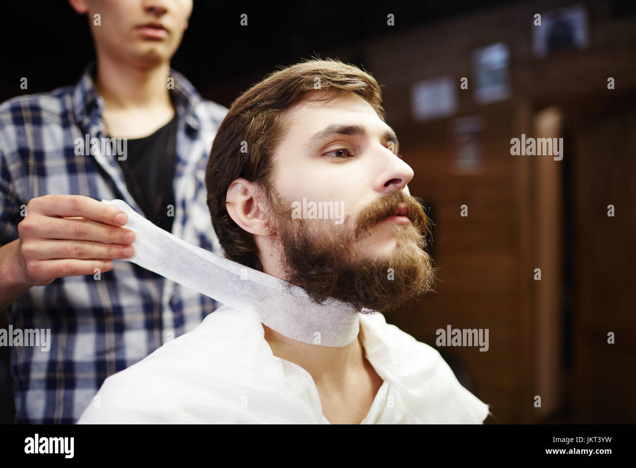 Barbiere di mettere la carta-collare intorno al collo del client Foto stock  - Alamy