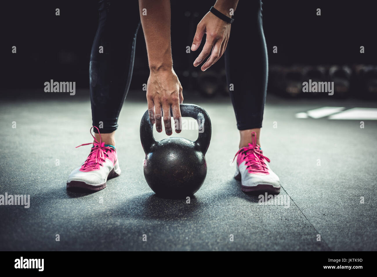 Donna dentro una palestra che lavora fuori con un kettlebell. Foto Stock