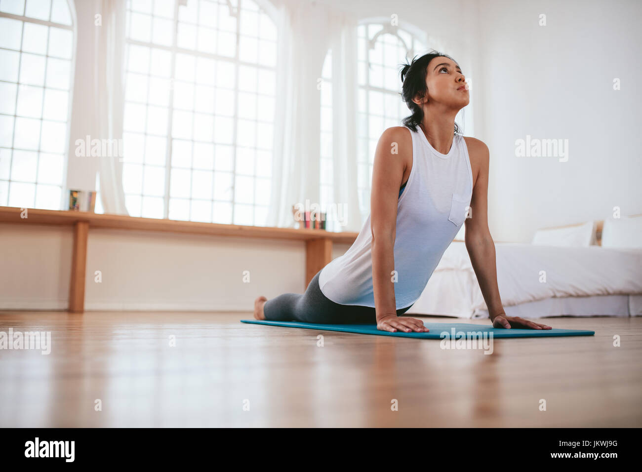 Colpo di montare la giovane donna a praticare yoga a casa. Sano giovane donna di esercizio. Foto Stock