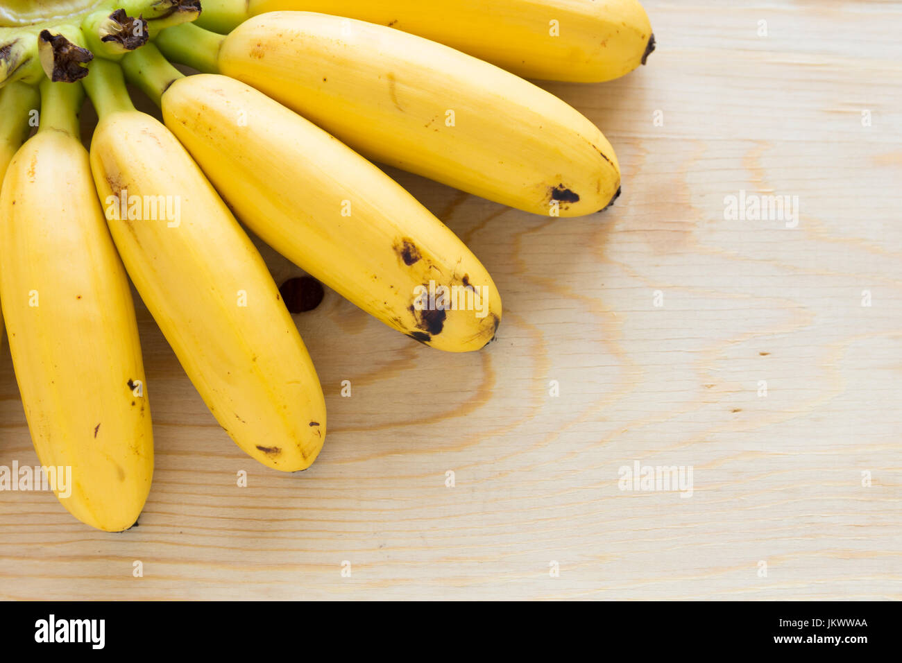 Banane mature sulla tavola di legno che è stato mangiato qualche pezzo Foto Stock