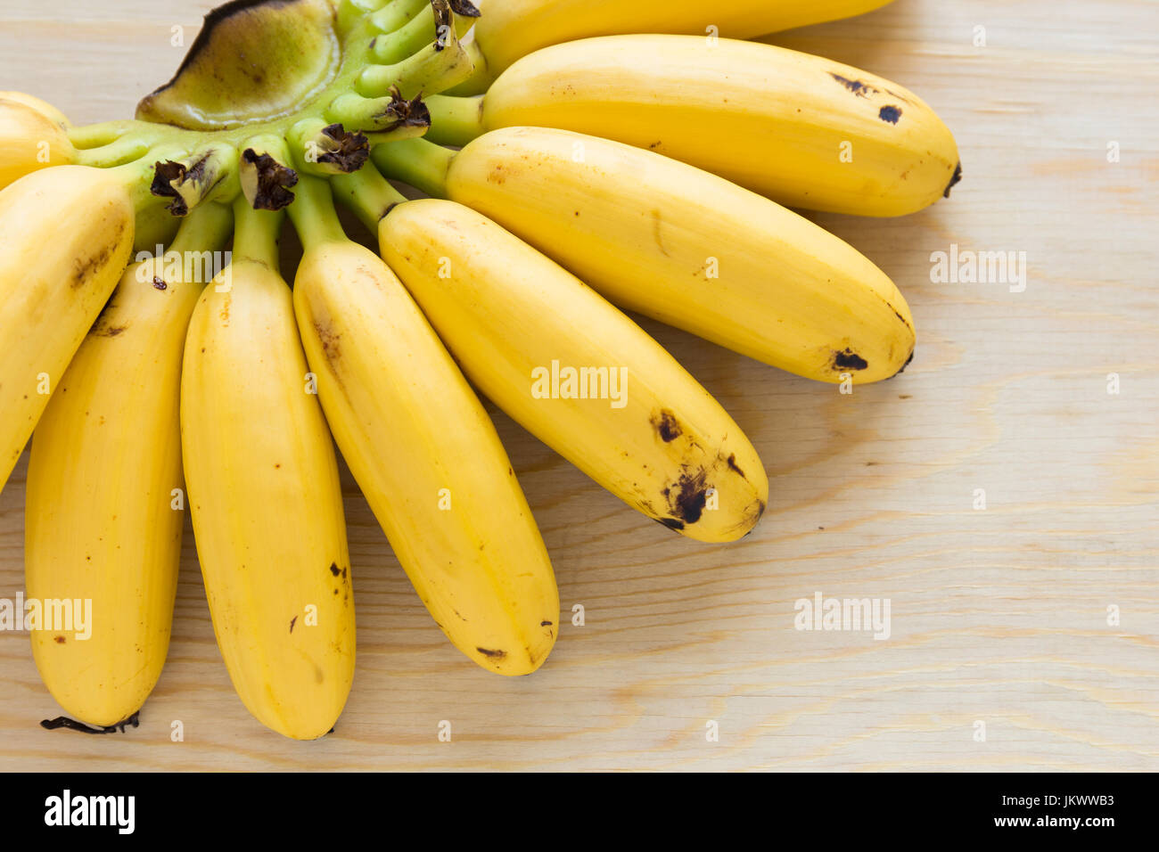 Banane mature sulla tavola di legno che è stato mangiato qualche pezzo Foto Stock