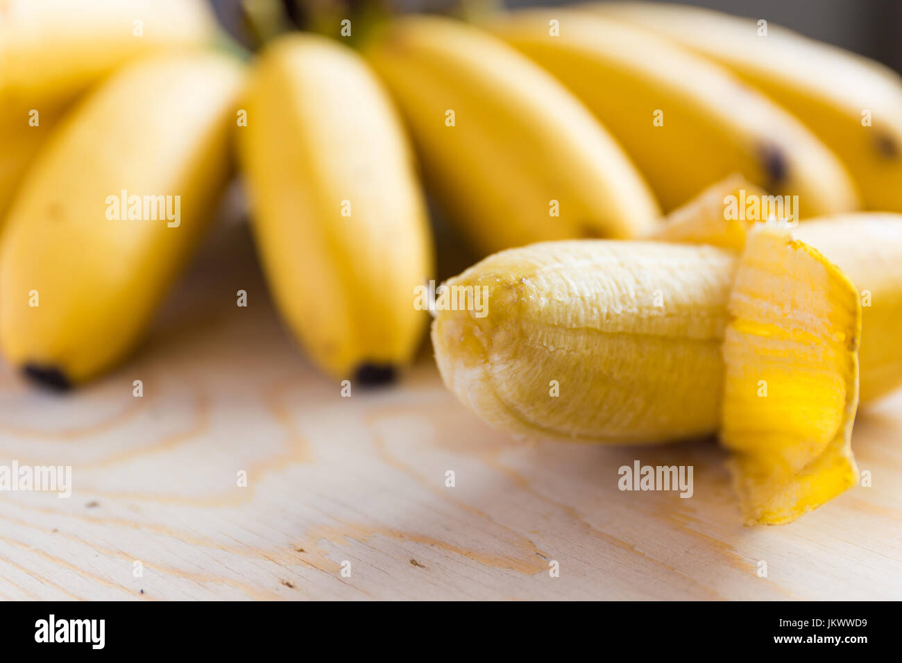 Banane mature sulla tavola di legno che è stato mangiato qualche pezzo Foto Stock