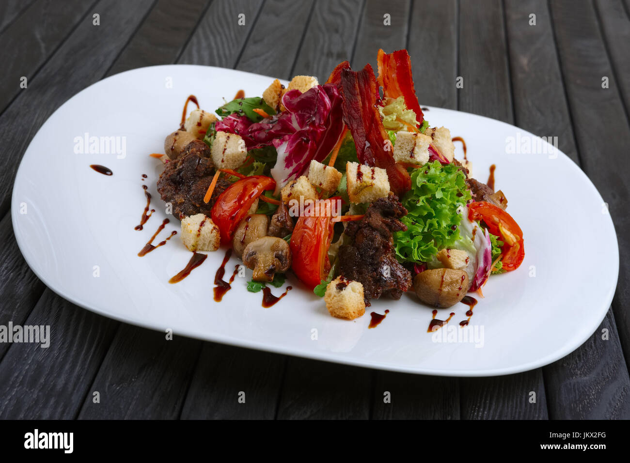 Con insalata di fegato, bacon, grigliate di pomodoro e pepe con cavolo rosso e funghi Foto Stock