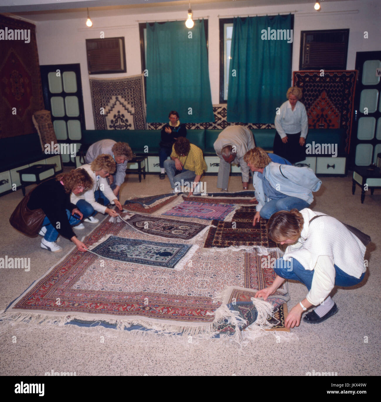 Touristen beim Teppichkauf in Kairouan, Tunesien 1980er Jahre. I turisti sono per acquistare tappeti come souvenir a Kairouan, Tunisia degli anni ottanta. Foto Stock