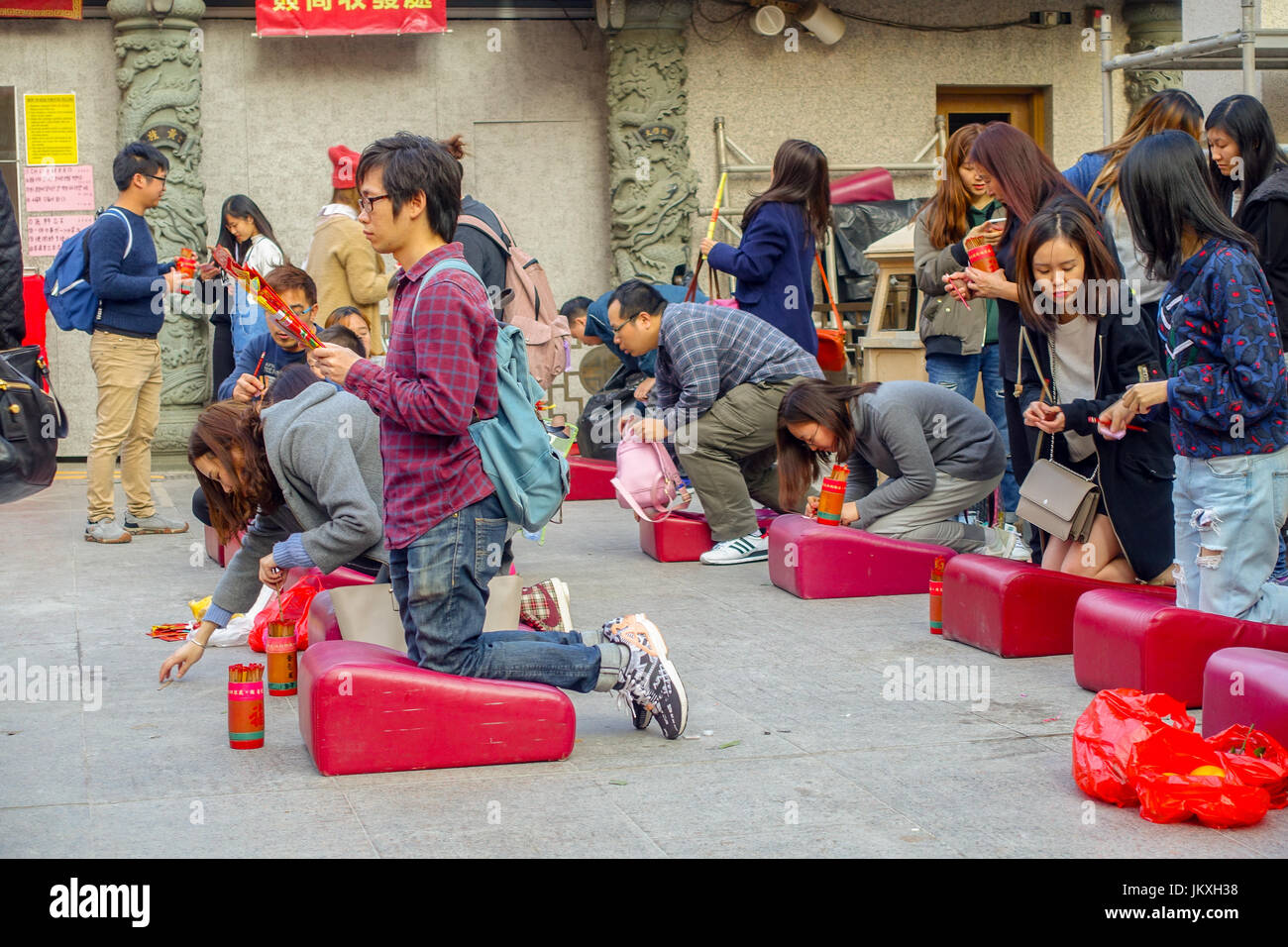 HONG KONG, CINA - 22 gennaio 2017: persone non identificate hanno pregato sulle loro ginocchia in un rosso pad morbido interno di Wong Tai Sin tempio buddista a pregare, a Hong Kong, Cina Foto Stock