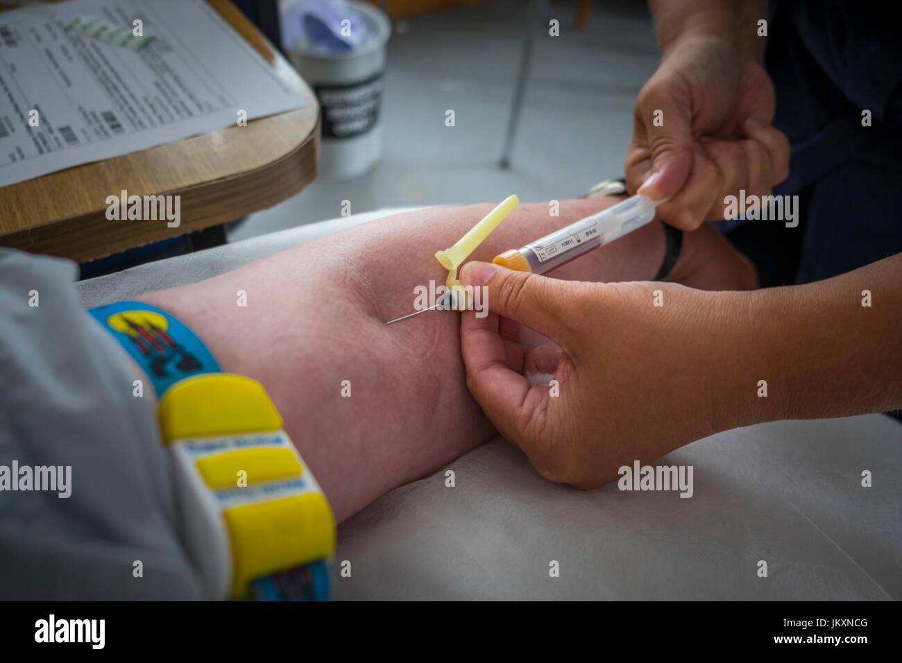 Un infermiere prendendo il sangue dal braccio di un paziente. Foto Stock
