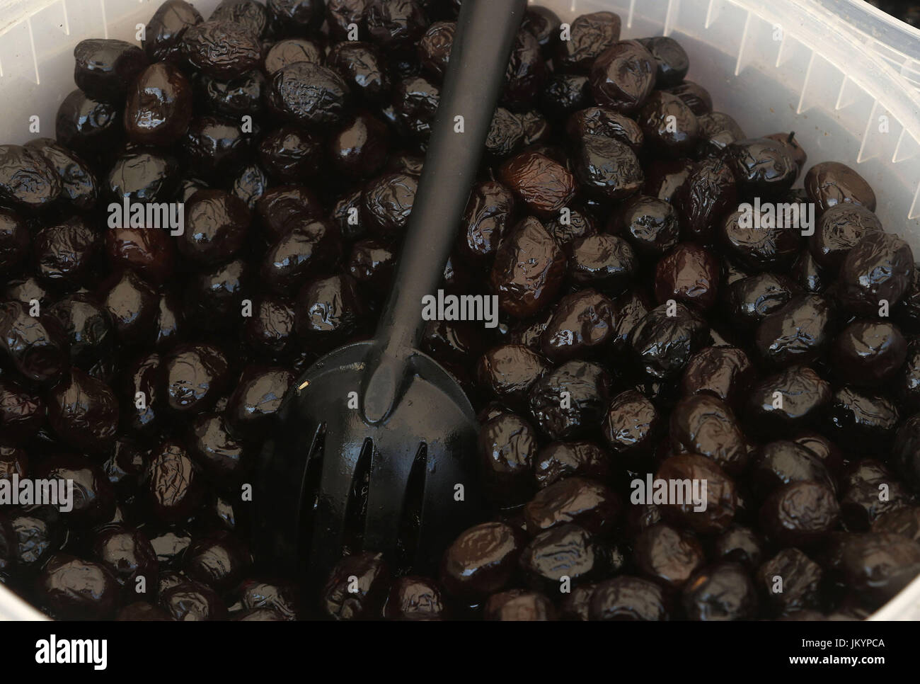 Una benna di Beldi olive nere con cucchiaio Foto Stock