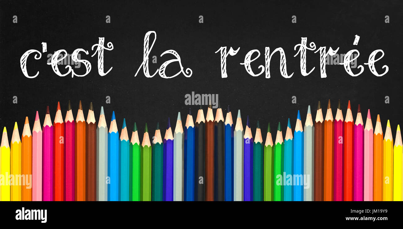 C'est la rentree (significato torna a schoo in francese) scritto su una scheda di colore nero lo sfondo con un onda di colorate matite in legno Foto Stock