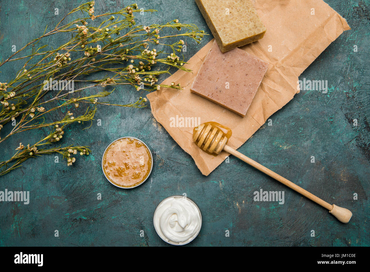 Vista ravvicinata di sapone artigianale, miele, fiori secchi e crema per cure di bellezza Foto Stock