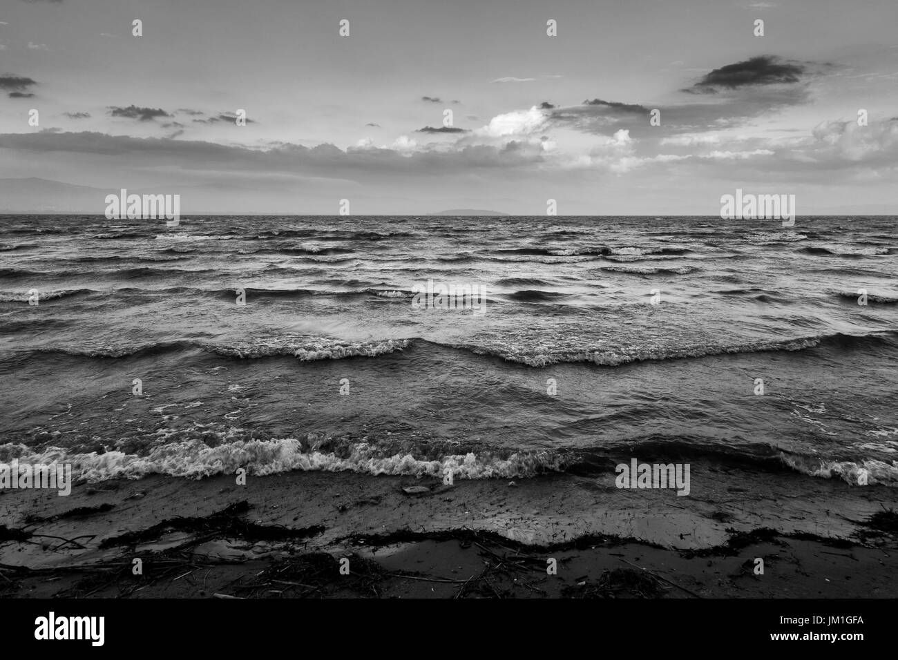 Onde su un lago vicino al tramonto, con una lontana isola Foto Stock