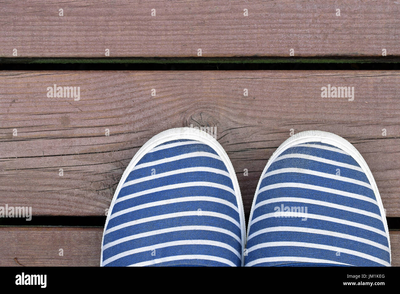 Stile marinaio blu e bianca a strisce scarpe sul dock in legno.. Foto Stock