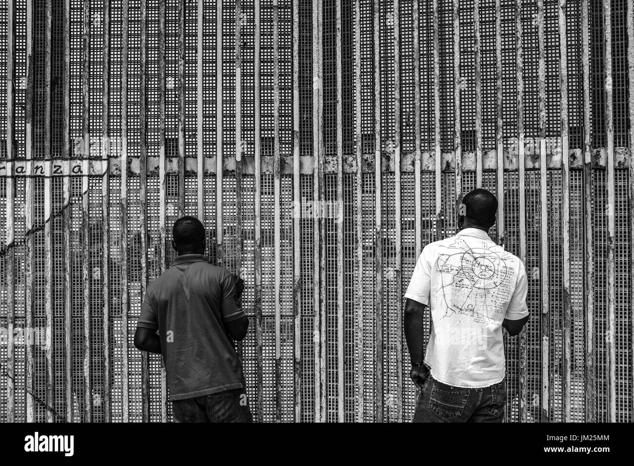 Tijuana, Baja California, Messico. Il 25 giugno, 2017. Gli immigrati haitiani a comunicare con i cittadini americani sull'altro lato della recinzione di confine in Tijuana, Baja California. Gli immigrati haitiani che viaggiano attraverso il Messico con speranze di incrocio in gli Stati Uniti trovati in tra Messico e Stati Uniti le politiche di immigrazione. Molti sono ora la scelta di stabilirsi in Baja California attraverso i visti umanitari. Credito: Joel Angelo Juarez/ZUMA filo/Alamy Live News Foto Stock