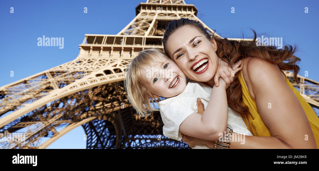 Turistica, senza dubbio, ma ancora in modo divertente. Ritratto di sorridere la madre e il bambino i turisti contro la Torre Eiffel a Parigi, Francia Foto Stock
