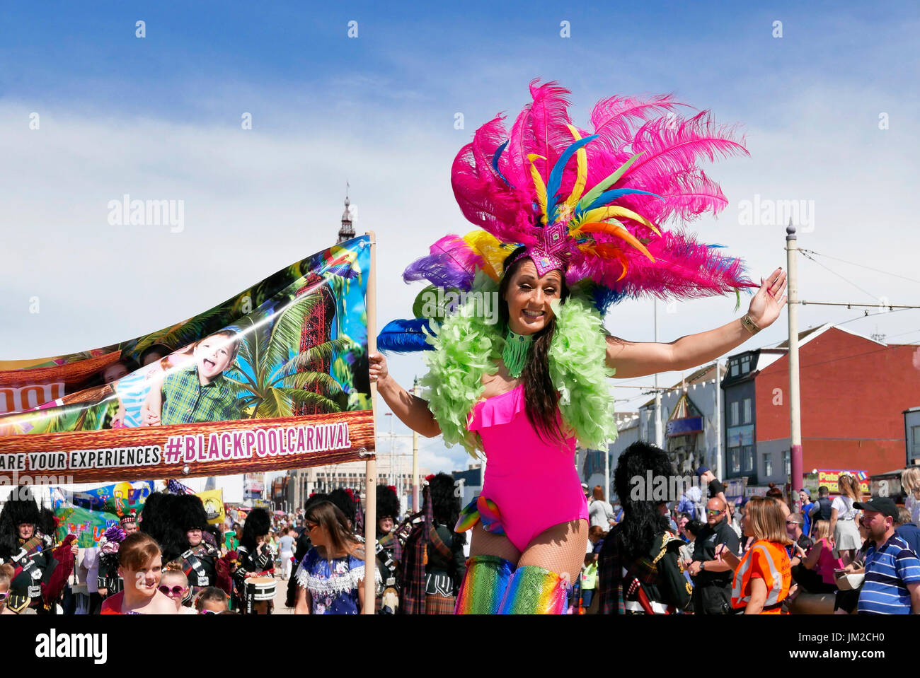 Blackpool Carnevale Internazionale. Affascinante ragazza su palafitte indossando costumi colorati sventolando la folla Foto Stock