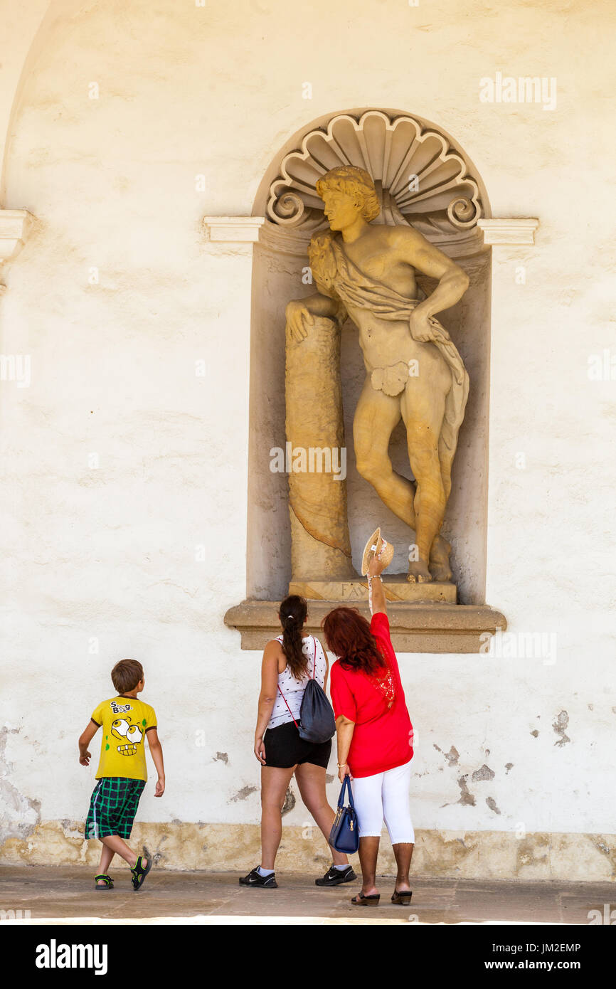 I turisti di fronte a una delle 44 statue di divinità antiche, Faun, Pleasure Garden, Kromeriz giardino, sito patrimonio mondiale dell'UNESCO Repubblica Ceca Foto Stock
