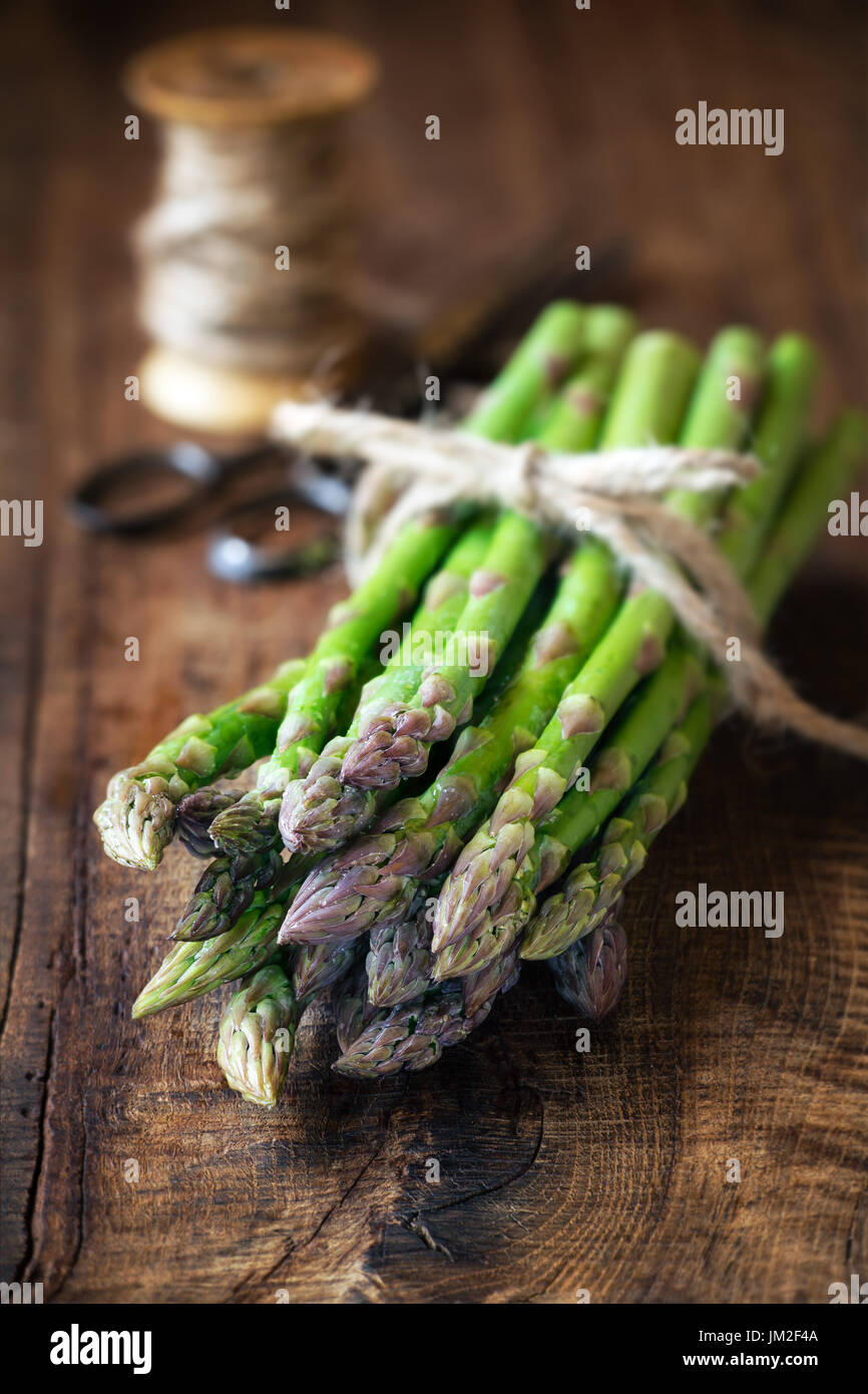 Bundle di asparagi freschi stocchi scuro su tavola in legno rustico Foto Stock